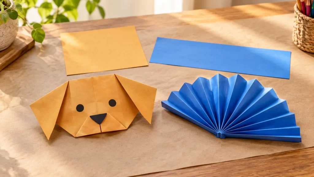 Papiroflexia fácil: dos figuras de papel paso a paso 1 Cara de perro de papel y abanico azul de acordeón sobre una mesa.