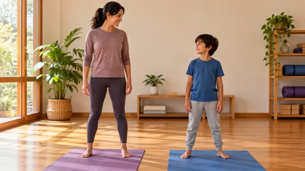 Tres posturas de yoga para niños: montaña, árbol y gato sentado 1 Una instructora adulta y un niño se preparan de pie en una sala despejada sobre dos esterillas.