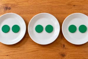 Tres platos reciben la misma cantidad de fichas de colores.