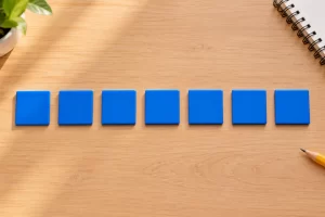 Siete fichas se ordenan en una sola fila sobre una mesa escolar.